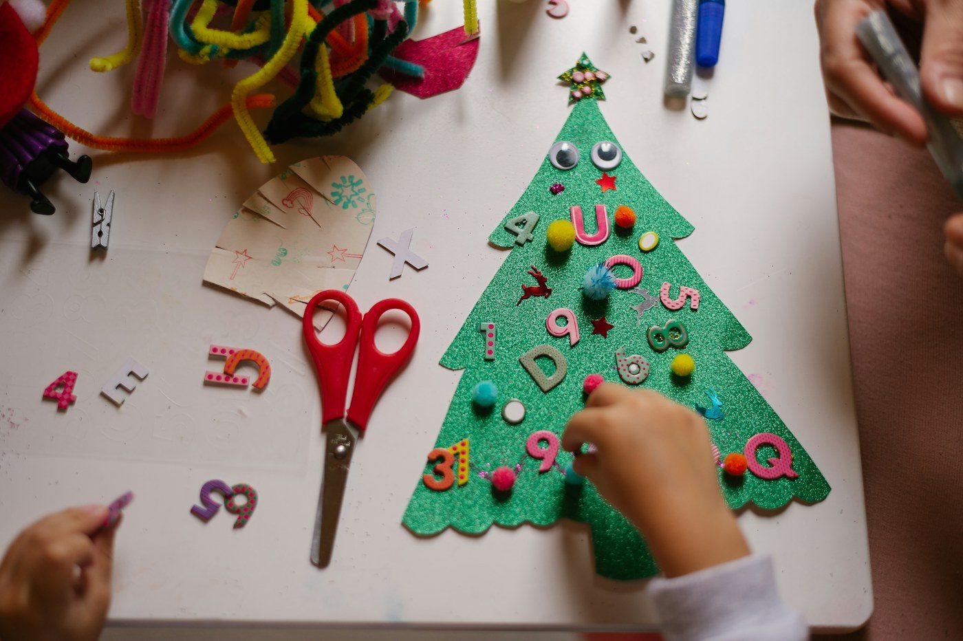 A child making a felt Christmas tree at an art class