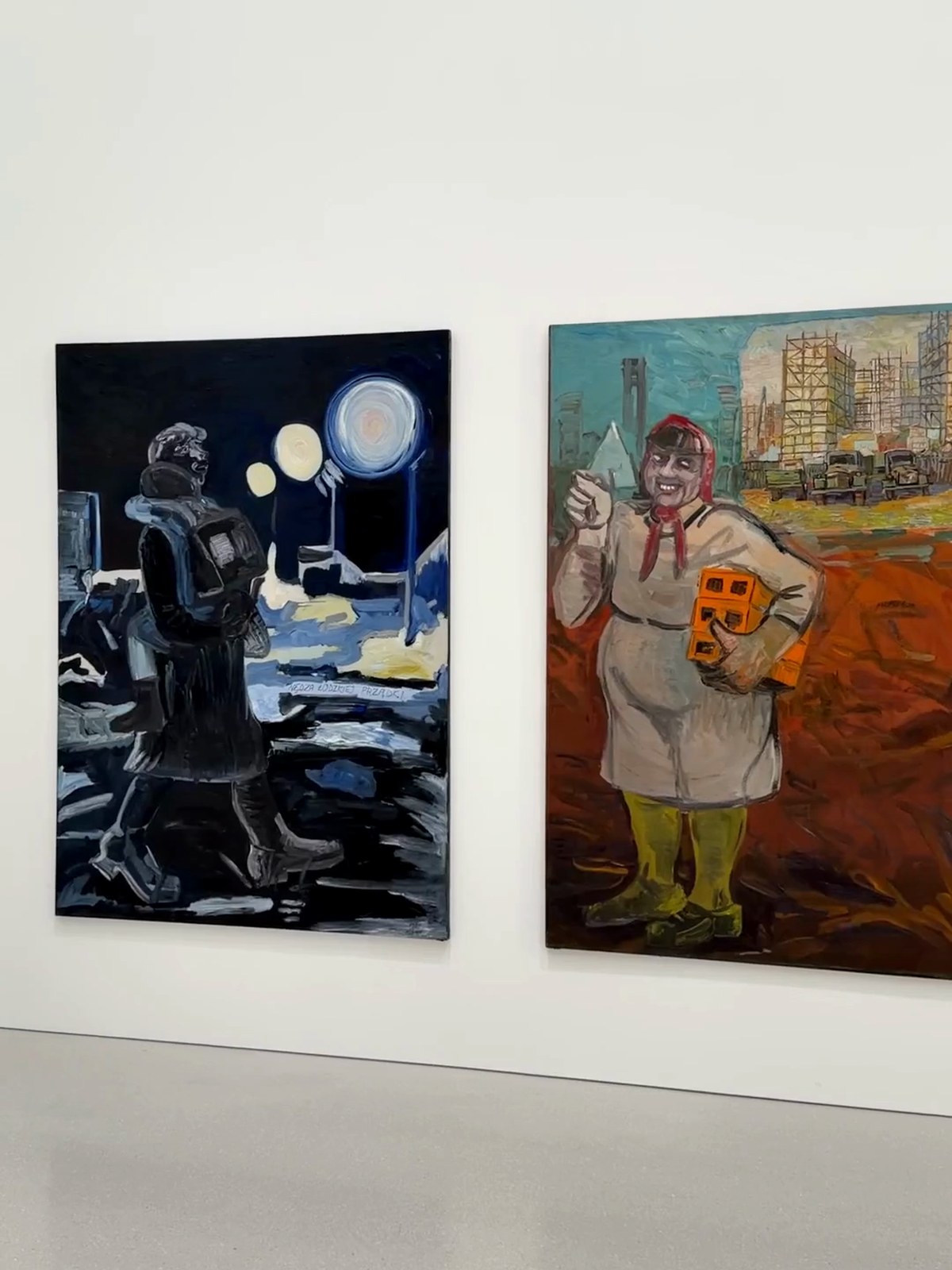Two figurative paintings hanging on a white gallery wall