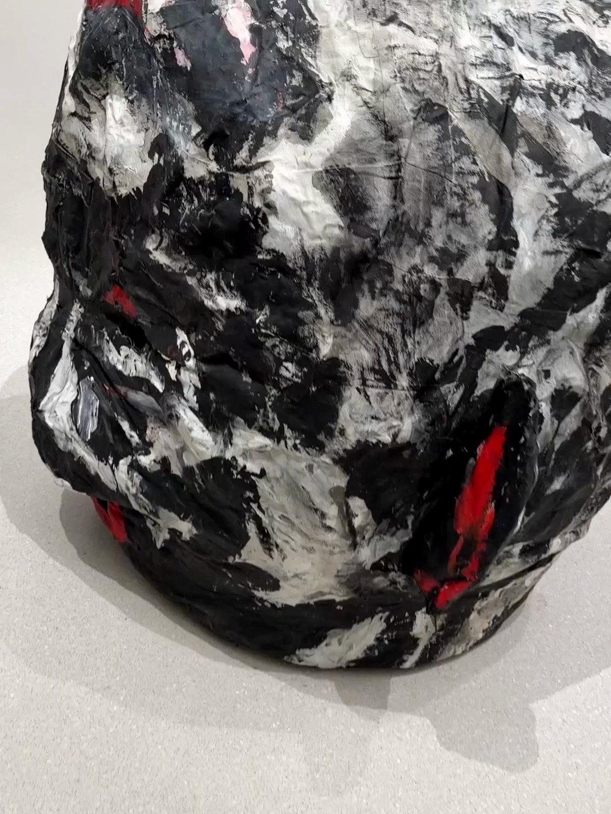 A large sculpted head painted in black and white, seen up close